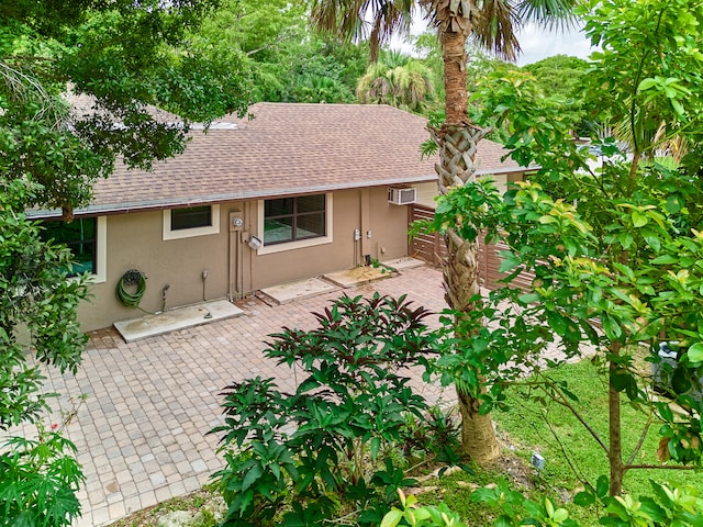 back of house with a wall unit AC and a patio area