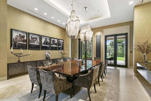 dining space featuring a notable chandelier, a tray ceiling, and french doors