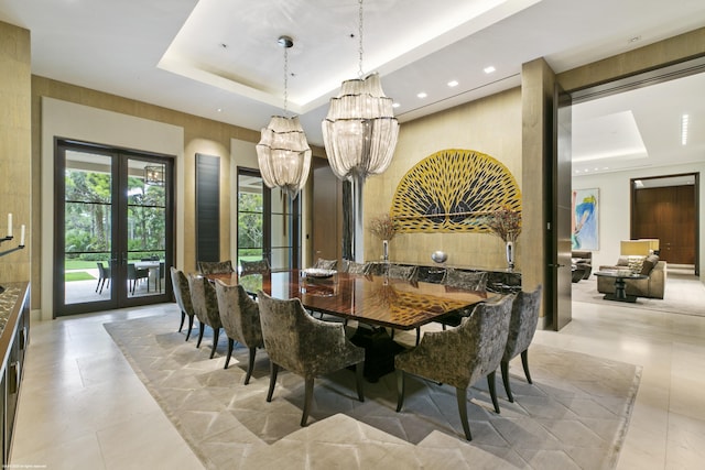 dining space with a tray ceiling and french doors