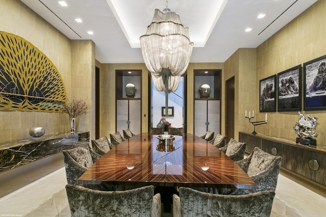 dining space featuring a raised ceiling, tile walls, and a notable chandelier