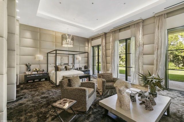 carpeted bedroom featuring a tray ceiling, a chandelier, and access to outside