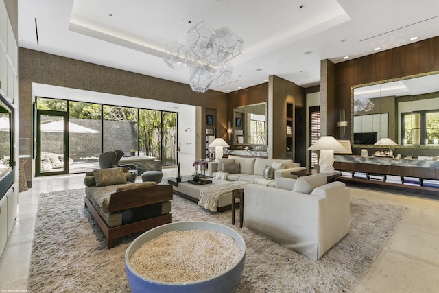 living room featuring a high ceiling, a chandelier, and a tray ceiling