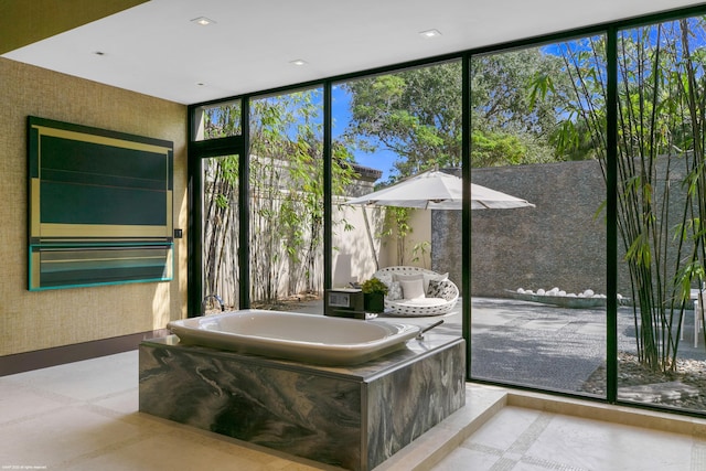 bathroom with a bath and a wall of windows