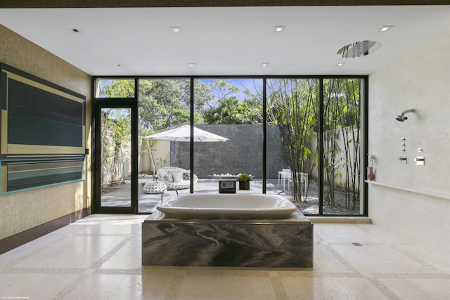 bathroom with a bathtub and expansive windows