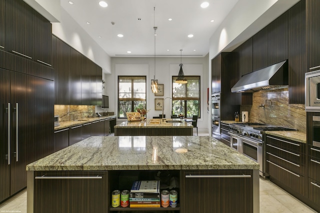 kitchen featuring light stone counters, ventilation hood, a center island, hanging light fixtures, and high quality appliances