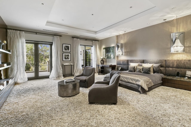 bedroom featuring french doors, access to exterior, and a raised ceiling