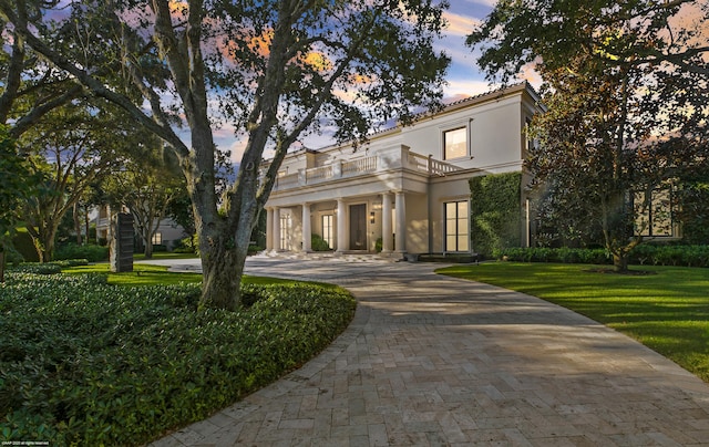 view of front of house with a balcony and a yard