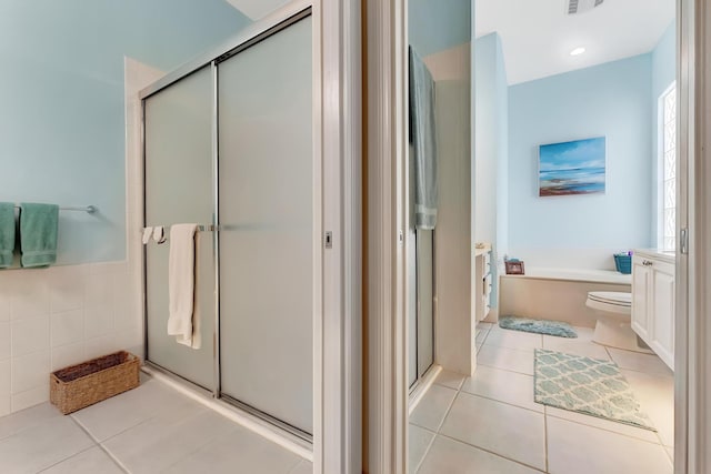 bathroom featuring tile walls, plus walk in shower, tile patterned flooring, and vanity