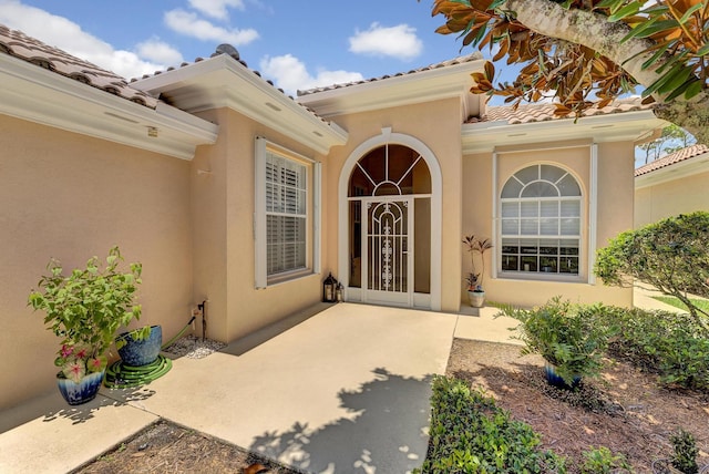 view of exterior entry with a patio area