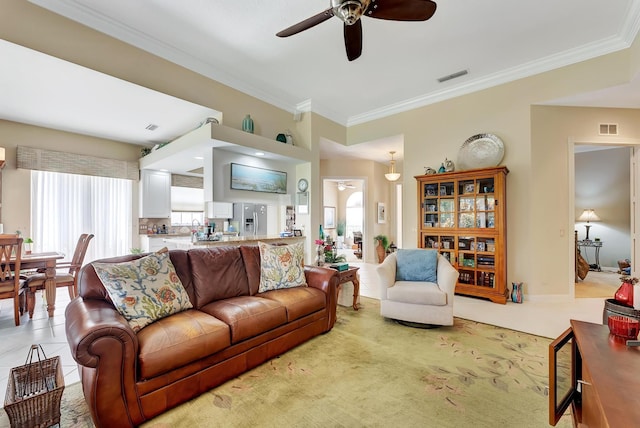 tiled living room featuring ceiling fan and crown molding