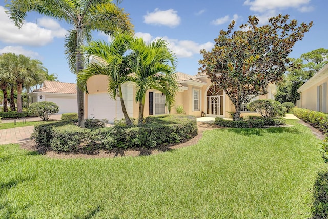 mediterranean / spanish-style home featuring a garage and a front yard