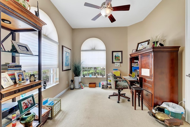 carpeted office space with ceiling fan