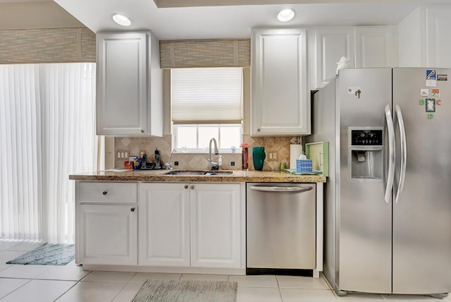 kitchen featuring sink, stainless steel appliances, white cabinets, and backsplash