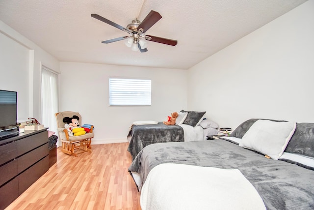 bedroom with a textured ceiling, light wood-type flooring, and ceiling fan