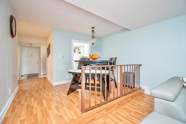 dining room with light hardwood / wood-style flooring and a textured ceiling