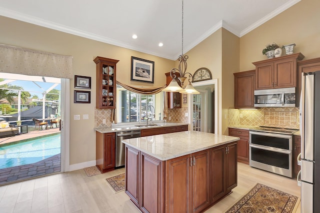 kitchen featuring decorative backsplash, appliances with stainless steel finishes, a center island, and pendant lighting