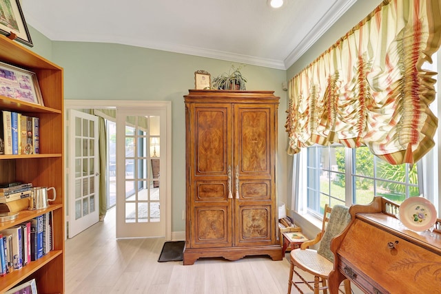 sitting room featuring ornamental molding, light hardwood / wood-style floors, french doors, and lofted ceiling