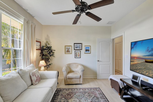 living room featuring ceiling fan and light hardwood / wood-style floors