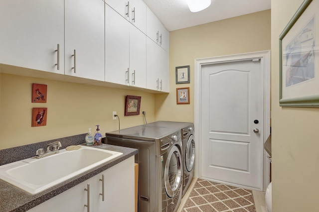 laundry room with cabinets, independent washer and dryer, and sink