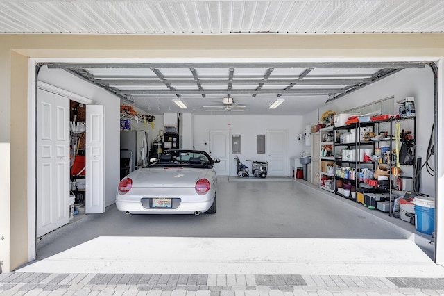 garage with stainless steel fridge, electric panel, and ceiling fan