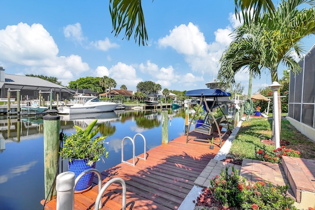 dock area with a lanai and a water view