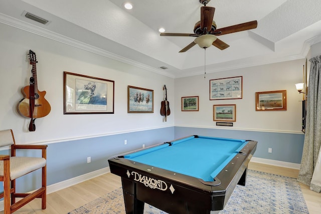 game room with a raised ceiling, ceiling fan, crown molding, light hardwood / wood-style flooring, and billiards