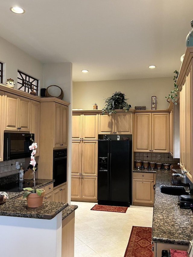 kitchen featuring recessed lighting, a sink, backsplash, dark stone counters, and black appliances