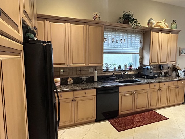 kitchen featuring tasteful backsplash, dark stone countertops, black appliances, a sink, and light tile patterned flooring