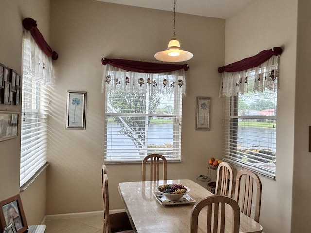 tiled dining space featuring baseboards