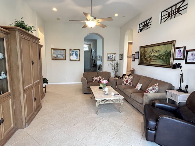 living room with arched walkways, ceiling fan, light tile patterned flooring, recessed lighting, and baseboards