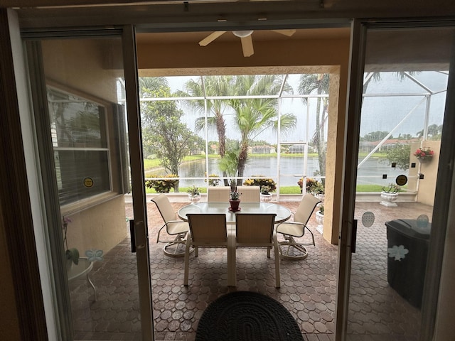 sunroom / solarium featuring ceiling fan, a water view, and a wealth of natural light