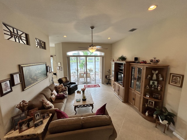 living area with light tile patterned floors, visible vents, a ceiling fan, a glass covered fireplace, and recessed lighting