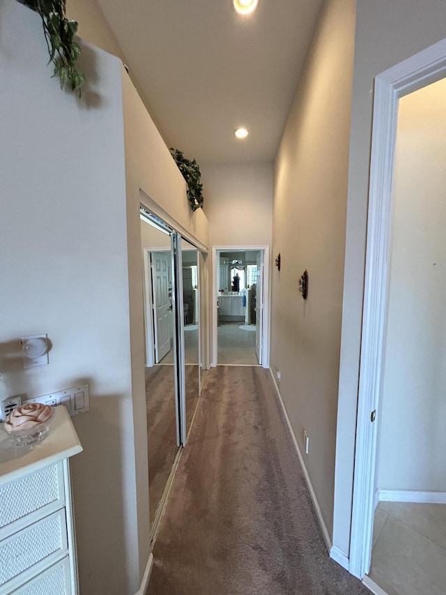 hallway featuring recessed lighting, carpet, a sink, and baseboards
