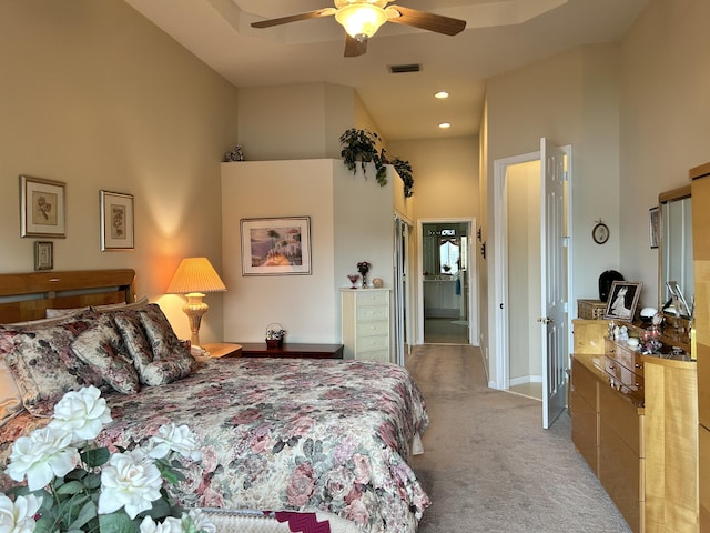 bedroom with recessed lighting, visible vents, light carpet, and a high ceiling