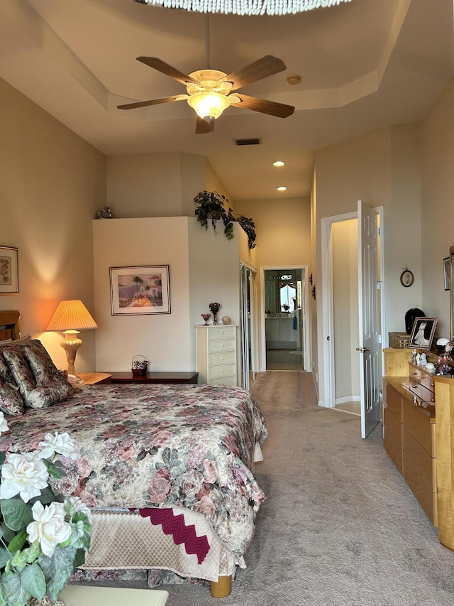 bedroom featuring ceiling fan, recessed lighting, visible vents, a tray ceiling, and carpet