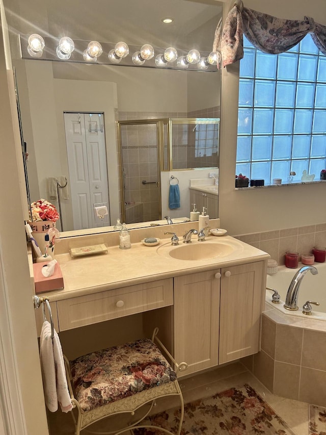 full bathroom featuring a stall shower, vanity, and a bath
