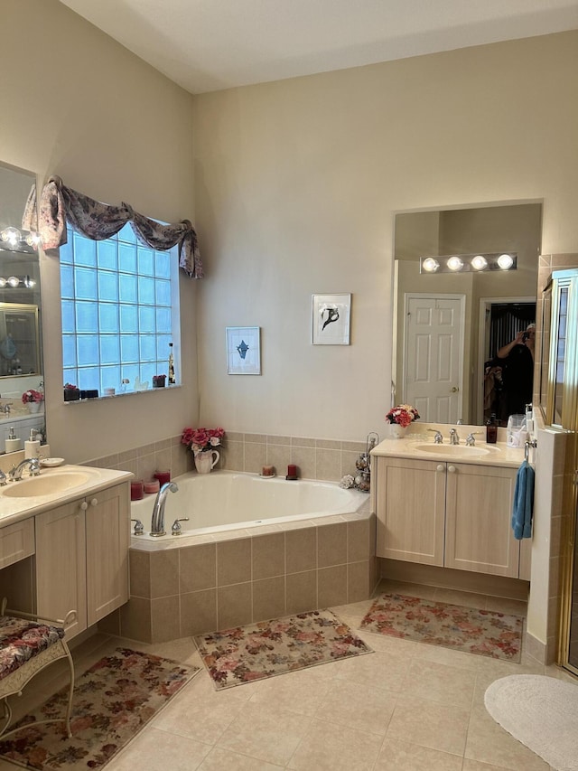 full bath with tile patterned floors, two vanities, a sink, and a bath