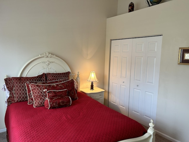 carpeted bedroom with a closet and baseboards
