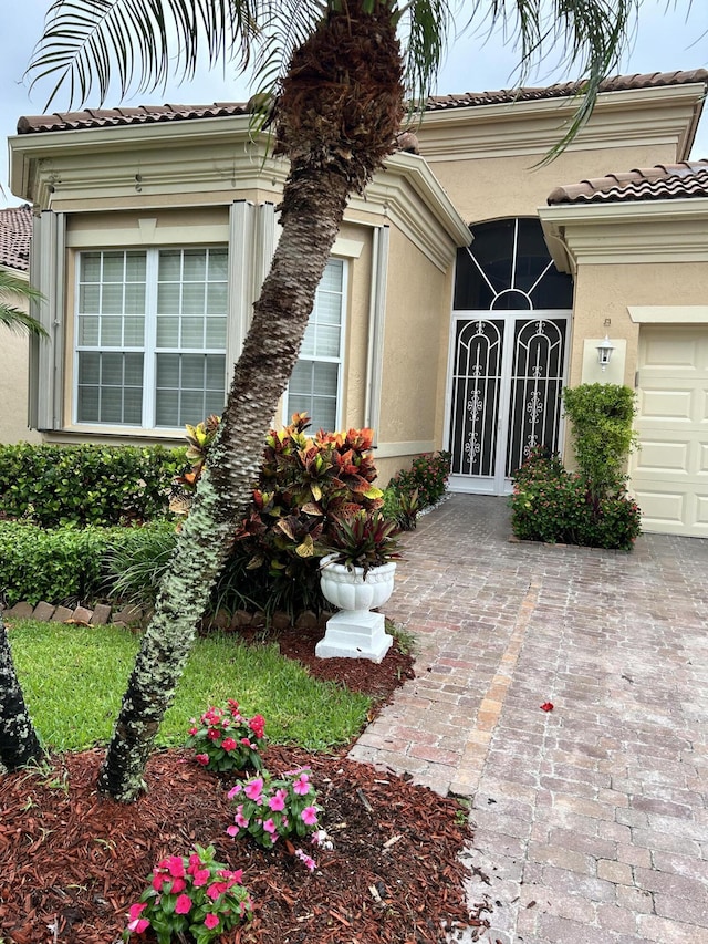 doorway to property featuring a tiled roof and stucco siding
