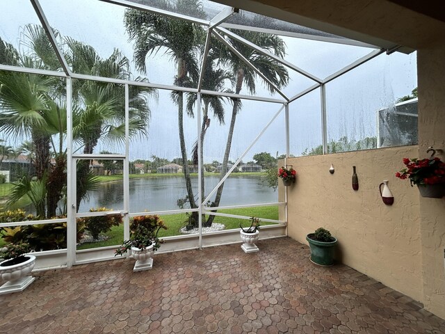 unfurnished sunroom featuring a water view