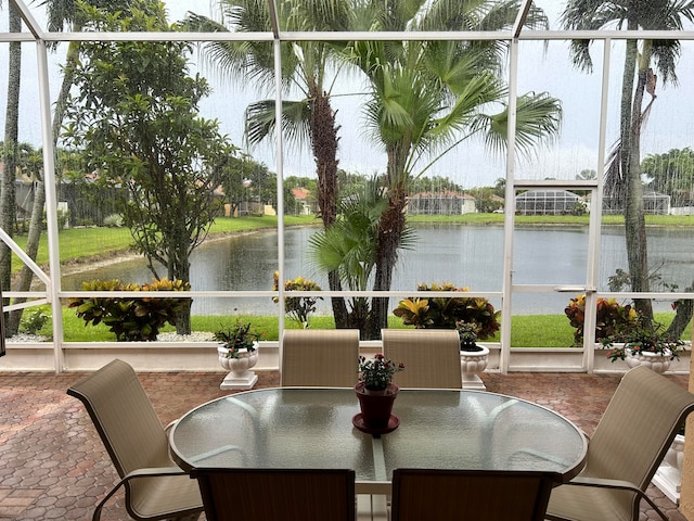 sunroom / solarium featuring a water view