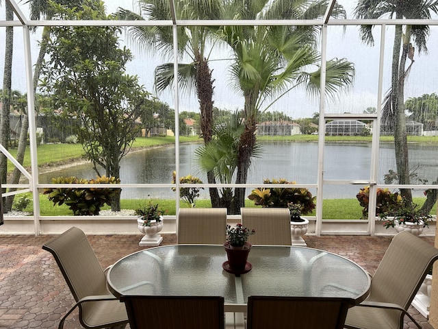 sunroom featuring a water view