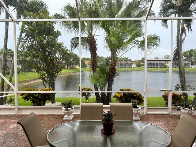 sunroom featuring a water view