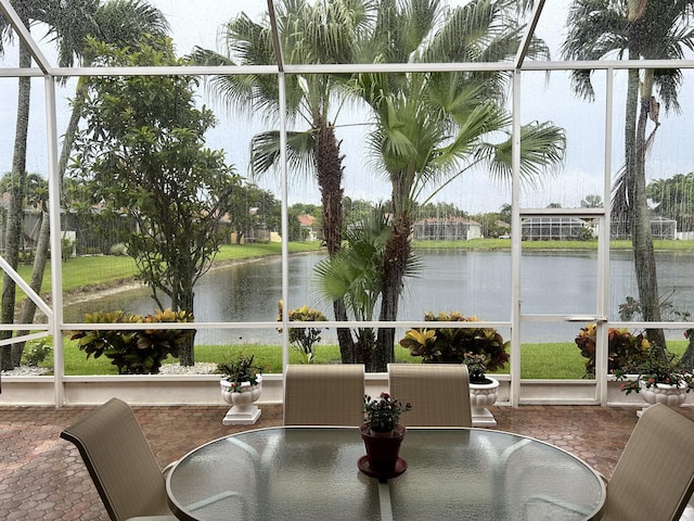 sunroom featuring a water view