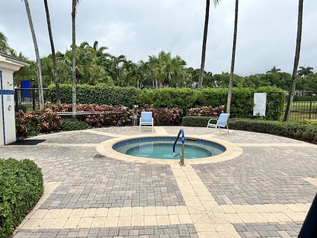view of swimming pool with a hot tub, fence, and a patio