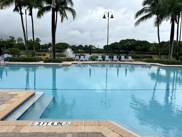 pool with a patio area and fence