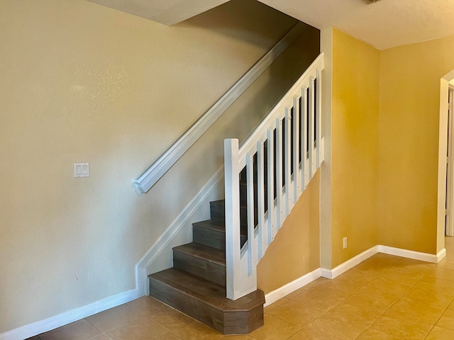 stairway featuring light tile patterned floors