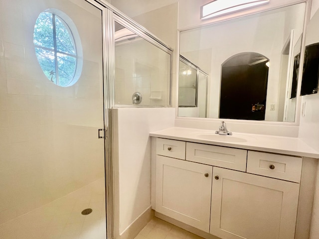 bathroom featuring tile patterned flooring, a shower with shower door, and vanity