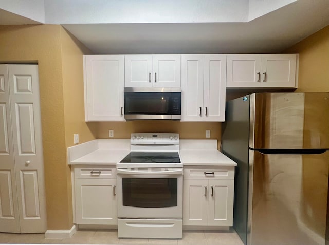 kitchen with white cabinetry, stainless steel appliances, and light tile patterned floors