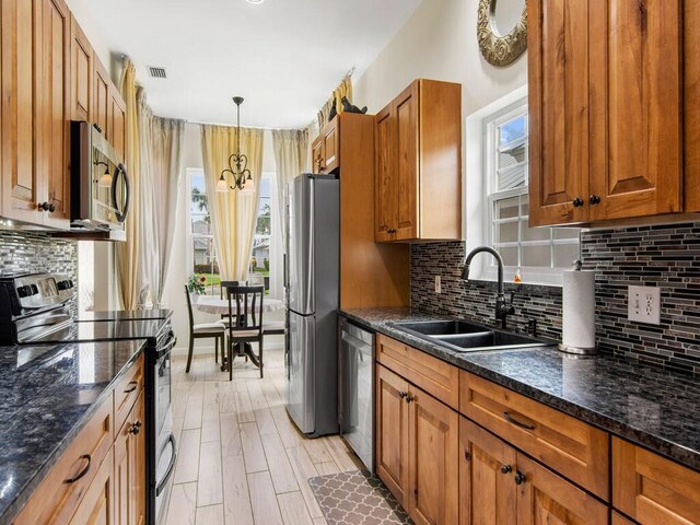 kitchen featuring sink, a wealth of natural light, hanging light fixtures, and appliances with stainless steel finishes